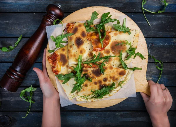 Calzone - nadziewane Pizza z szynką, grzyby, rukolą i serem. — Zdjęcie stockowe
