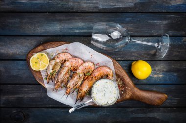 Izgara karides veya bilinenlerin beyaz sos ve yarım limon ile.