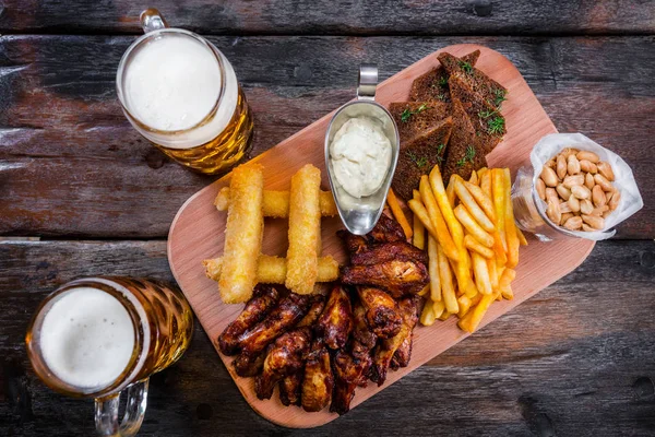 Aperitivos surtidos de cerveza con tazas de cerveza — Foto de Stock