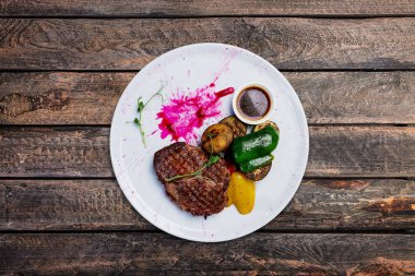 Beyaz bir tabak ızgara sebzeli dana biftek ızgara.