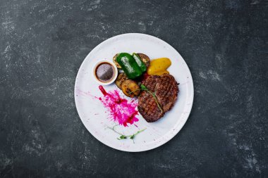 Beyaz bir tabak ızgara sebzeli dana biftek ızgara.