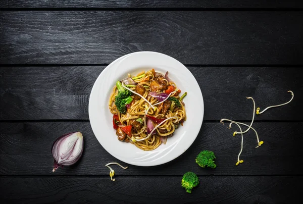 Udon stir fry erişte et ya da tavuk ve sebze beyaz bir plaka ile.
