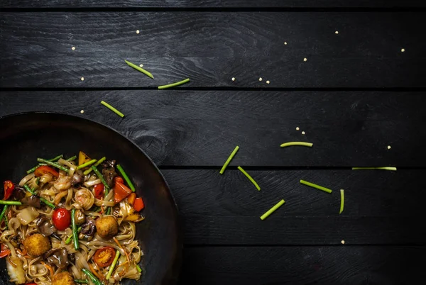 Se amestecă tăiței prăjiți în wok-ul tradițional chinezesc. Spațiu pentru text. Privire de sus . — Fotografie, imagine de stoc