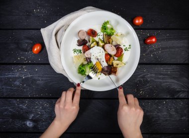 Haşlanmış yumurta ve sosis ile ızgara sebze salatası.