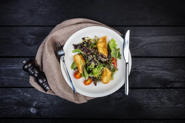 Salada com salmão em farinha de rosca com alface e sementes de sésamo . — Fotografia de Stock