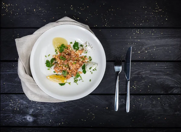 Ταρτάρ σολομού σερβίρεται στο άσπρο πιάτο. — Φωτογραφία Αρχείου