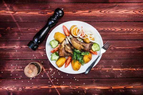 Kazan kebab en el plato con una picadora de pimienta en el fondo de madera . — Foto de Stock