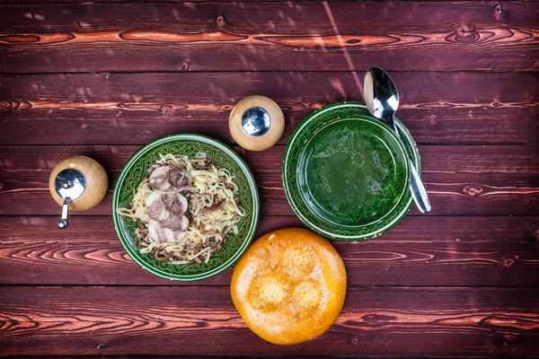 Naryn com caldo e pão tandyr. De carne de cavalo ou cordeiro e macarrão. Com um moedor de pimenta. Cozinha uzbeque Fotografia De Stock