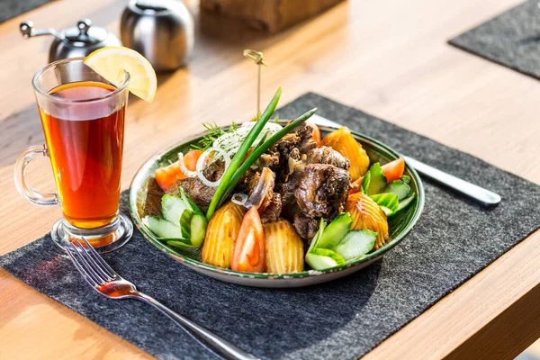 Kazan kebab en el plato con una taza de té — Foto de Stock