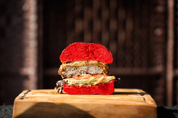 Κόκκινο βελούδο Burger σε μια ξύλινη σανίδα Εικόνα Αρχείου