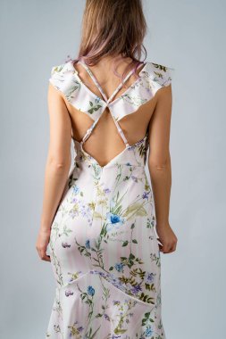 Beyaz ipek elbiseli, çiçekli bir kız, beyaz bir arka planda izole edilmiş..