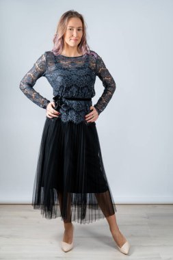 Siyah tişörtlü, siyah etekli, dantel ceketli, beyaz arka planda izole edilmiş bir kız..