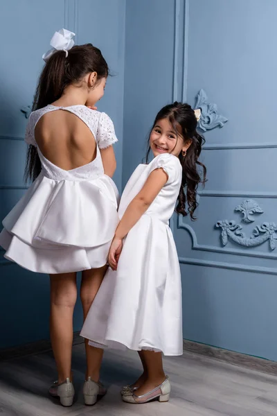 Dos Niños Vestidos Blancos Tacones Beige Sobre Fondo Gris Imagen De Stock