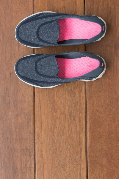 Голубая спортивная повседневная обувь на деревянном фоне — стоковое фото