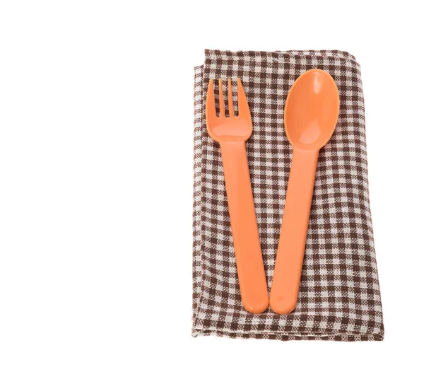 橙色匙子和叉子用褐色餐巾被隔绝在白色 — 图库照片