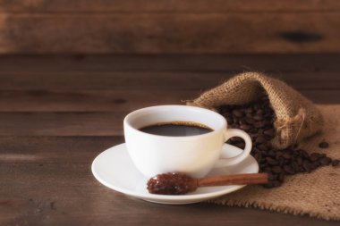 Eski ahşap masa kahve ve şeker çubuğa fincan.