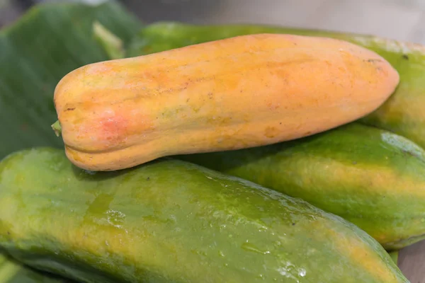 Färsk papaya frukt på gröna bananer lämna bakgrund, stilleben — Stockfoto