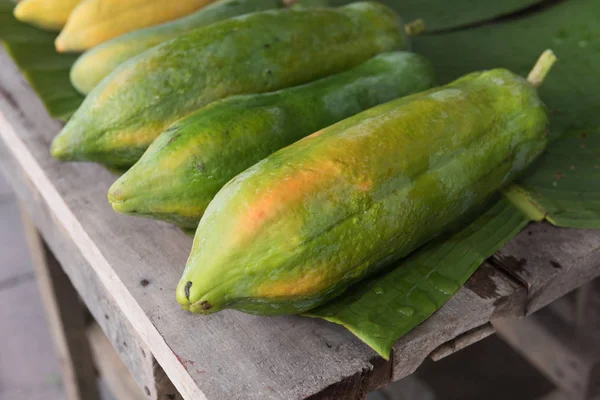 Fruits de papaye frais sur fond de banane verte laisser, nature morte — Photo