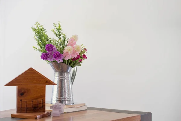 Mesa de madeira bem-vinda com vaso de flores e ícone da casa sobre o bac branco — Fotografia de Stock