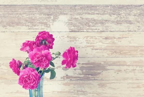 グランジ木製の上に青い花瓶にピンクのバラの花のある静物 — ストック写真