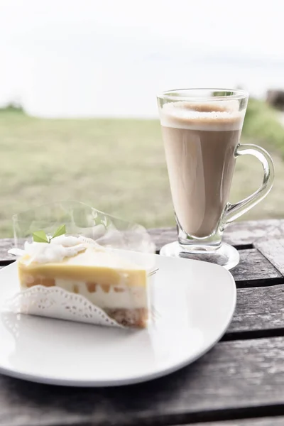 Taza de café y pastel de mango con cobertura de coco en ba hierba verde —  Fotos de Stock