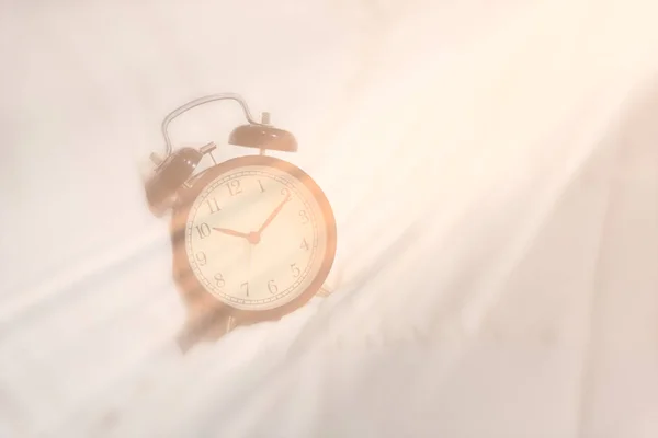 Alarm clock set on white sheet with morning light awake — Stock Photo, Image