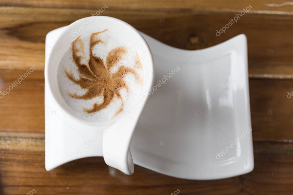 Cup of coffee latte art on geunge wooden background