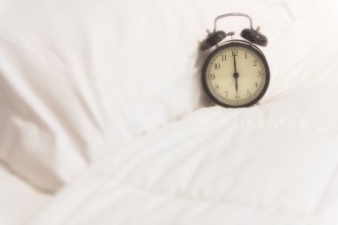 Alarm saati sabah ışık ile beyaz kağıda uyanık
