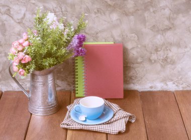 Mavi kahve fincanı ve defter çiçek ile ahşap masa üzerinde de olabilir