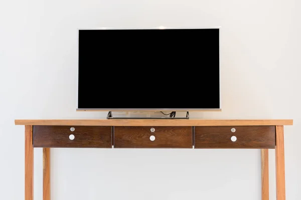 Led smart TV on wooden shelf over white wall background