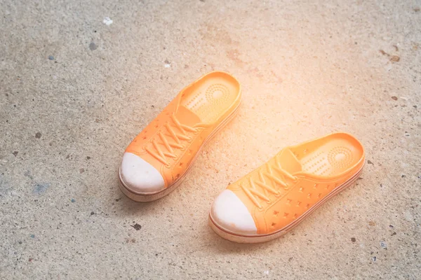 Πορτοκαλί παπούτσια στον τοίχο τσιμέντου — Φωτογραφία Αρχείου