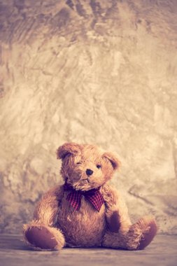 Sevimli tombul oyuncak ayı oyuncak sit çimento duvar arka planda, retro etkisi yalnız