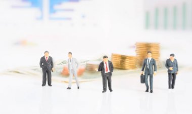 Miniture başarı işadamı takım çalışması sikke ve grafik grafik arka planı ile Toplantı