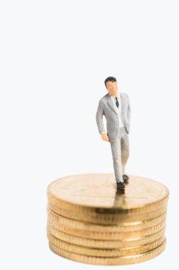 Altın sikke üzerinde beyaz arka plan izole kürsüye gri takım miniture başarı işadamı