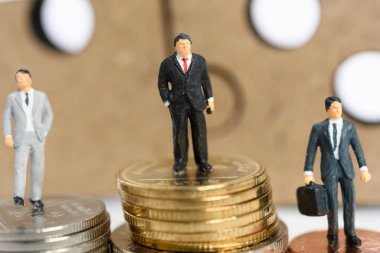 Minyatür iş adamları iş competi para sikkeleri üzerinde durmak