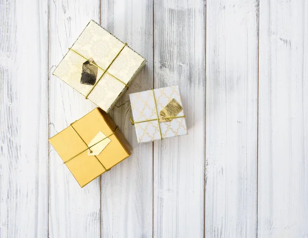 Kerst gouden geschenkdozen ingesteld op witte houten achtergrond, plat — Stockfoto