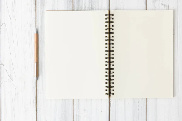 Notebook e lápis marrom sobre fundo mesa de madeira branca, plana la — Fotografia de Stock