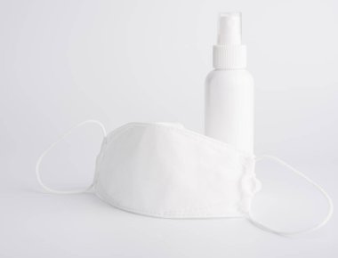 Beyaz maske mikrop koruması ve jel alkolü ya da el dezenfektanı spreyi şişesi beyaz arka planda kurulmuş korona sirkinden korumak için.