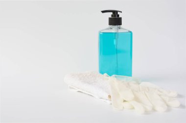 Coronavirus mikrobu koruyucu eldivenler ve el temizleyici jel şişesi beyaz arka planda el hijyen virüsü koruması için.