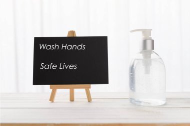 Ellerinizi yıkayın. Metin ve el dezenfektanı ya da beyaz ahşap masada sıvı sabun.