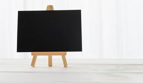 白い木のテーブルと背景にマッサージのための空白の黒板 — ストック写真