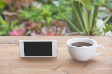 Kahverengi ahşap arka planda, beyaz fincanda koyu kahve.