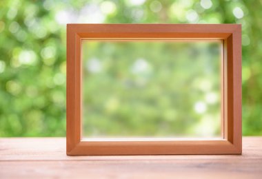 Yeşil bulanık arkaplan ile ahşap tablo üzerindeki metin için kopyasına sahip resim çerçevesi