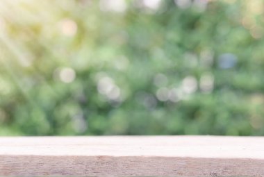 Ürünler için alanı olan ahşap masa ve doğa yeşil arkaplan, retro etkisi