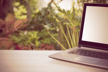 Yeşil bahçe arka planına sahip boş beyaz ekran tahta tablolu bilgisayar laptopu, retro etkisi