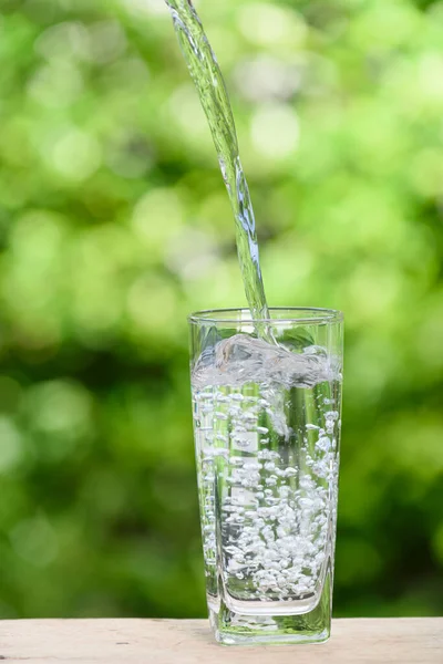 Versare Acqua Dolce Vetro Sul Tavolo Legno Con Sfondo Verde — Foto Stock