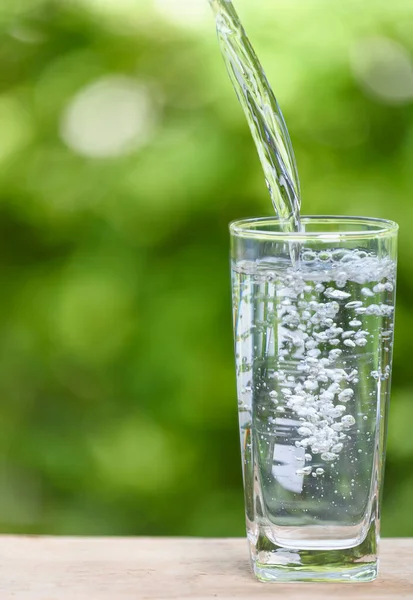 Pouring Fresh Water Glass Wood Table Green Nature Background — Stock Photo, Image