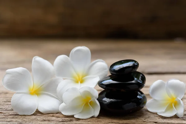 Stapel Van Zwarte Zen Stenen Frangipani Bloem Rustieke Houten Achtergrond — Stockfoto