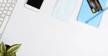 Covid-19 ya da dizüstü bilgisayarı, not defteri, tıbbi maskesi, kredi kartı ve faresi olan Coronavirus 'a bağlı ev konseptinden çalışmalar