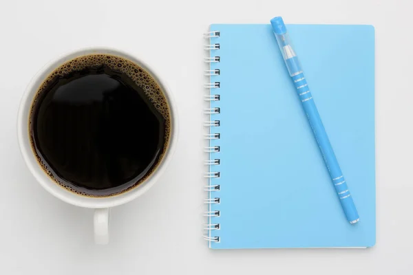 Kaffekopp Och Blå Anteckningsbok Med Penna Vit Bakgrund Ovanifrån — Stockfoto